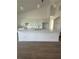 Bright kitchen featuring white cabinets, a large island, modern pendant lights, and sleek tile flooring at 8136 Sweden Blvd, Punta Gorda, FL 33982