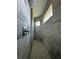 Walk-in shower with gray tile walls, dual shower heads, and pebble flooring at 8136 Sweden Blvd, Punta Gorda, FL 33982