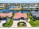 Aerial view of a single story home with red tile roof, landscaping, and a neighborhood canal in view at 815 Via Formia, Punta Gorda, FL 33950