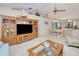 Open-concept living room featuring a large entertainment center, neutral colors, and views into dining and outdoor pool at 815 Via Formia, Punta Gorda, FL 33950
