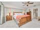 Cozy main bedroom featuring a decorative wood bed frame, neutral walls, and en suite bathroom at 815 Via Formia, Punta Gorda, FL 33950
