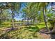 A serene backyard view of a pond surrounded by lush landscaping and trees at 9020 Eagle Bay Ct, North Port, FL 34287