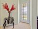 Foyer features a decorative glass door, tile flooring, and a unique accent table with a flower arrangement at 9020 Eagle Bay Ct, North Port, FL 34287