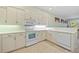 Well-lit kitchen features white cabinets, countertops, and modern appliances at 9020 Eagle Bay Ct, North Port, FL 34287