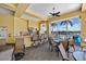 Outdoor kitchen features a grill, bar-style seating, ceiling fan, and pool views at 9020 Eagle Bay Ct, North Port, FL 34287
