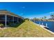 Waterfront backyard with a private boat dock and lush landscaping, offering serene water views at 1206 Winward Ct, Punta Gorda, FL 33950