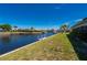 Scenic backyard view featuring a waterfront canal, lush green grass, and a private boat dock at 1206 Winward Ct, Punta Gorda, FL 33950