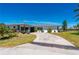 Single-story home featuring a tile roof and circular driveway surrounded by a well-maintained lawn and mature landscaping at 1206 Winward Ct, Punta Gorda, FL 33950