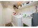 Laundry room features a utility sink, washer, dryer, and storage shelves at 1206 Winward Ct, Punta Gorda, FL 33950