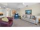 Cozy living room featuring neutral carpeting, comfortable seating, and a view into the kitchen area at 1206 Winward Ct, Punta Gorda, FL 33950