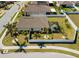Aerial view of fenced-in backyard with screened patio, mature palm trees, and manicured lawn at 15288 Mille Fiore Blvd, Port Charlotte, FL 33953