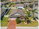 Aerial view of a well-maintained home with a brick driveway, complemented by palm trees and a white fenced backyard at 15288 Mille Fiore Blvd, Port Charlotte, FL 33953