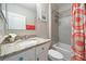 Bathroom featuring granite countertops, framed mirror and shower with orange patterned shower curtain at 15288 Mille Fiore Blvd, Port Charlotte, FL 33953