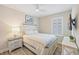 Cozy bedroom featuring ceiling fan, a large window and wood flooring at 15288 Mille Fiore Blvd, Port Charlotte, FL 33953