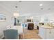 Open-concept dining area with a white table, views into the living room, and a modern chandelier at 15288 Mille Fiore Blvd, Port Charlotte, FL 33953