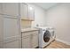 Bright laundry room with gray cabinets, countertop, and front-load Samsung washer and dryer at 15288 Mille Fiore Blvd, Port Charlotte, FL 33953