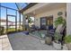 Inviting screened patio with comfortable seating, plants, and sliding glass door access to the house at 15288 Mille Fiore Blvd, Port Charlotte, FL 33953