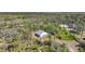An aerial view of a quaint, white home nestled among lush green trees and native vegetation at 16180 Forest Glen Ct, Punta Gorda, FL 33982