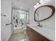 Modern bathroom features a glass enclosed tub/shower combination, and a wood vanity with stone countertop at 16180 Forest Glen Ct, Punta Gorda, FL 33982