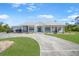 Charming home featuring a metal roof, covered porch, and circular driveway with ample parking at 16180 Forest Glen Ct, Punta Gorda, FL 33982