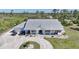 Charming single-story home with a metal roof, circular driveway, and a beautifully landscaped front yard at 16180 Forest Glen Ct, Punta Gorda, FL 33982