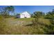Exterior detached garage with three bays and a white exterior sits amidst a large lawn at 16180 Forest Glen Ct, Punta Gorda, FL 33982