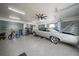 Spacious garage featuring durable epoxy flooring, steel roll-up doors, and an antique car at 16180 Forest Glen Ct, Punta Gorda, FL 33982