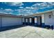 Inviting home with attached garage, long driveway, and vibrant blue trim, enhanced by well-maintained landscaping at 234 Tait Se Ter, Port Charlotte, FL 33952