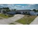 Desirable home with long driveway, attached garage, and lush lawn, enhanced by vibrant blue trim and landscaping at 234 Tait Se Ter, Port Charlotte, FL 33952
