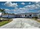 Charming home featuring long driveway, attached garage, and lush lawn, enhanced by vibrant blue trim and landscaping at 234 Tait Se Ter, Port Charlotte, FL 33952