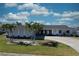 Charming single-story home featuring blue trim accents and well-maintained lawn with delightful palm tree landscaping at 234 Tait Se Ter, Port Charlotte, FL 33952