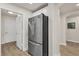 Hallway with stainless steel refrigerator and updated floors at 240 W End Dr # 312, Punta Gorda, FL 33950