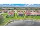 An aerial view highlights a home with a screened-in pool, set against a scenic lake, with neighboring properties and green lawns at 24407 Riverfront Dr, Punta Gorda, FL 33980