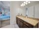 Bathroom with dark wood cabinets, granite countertops, tile flooring, and doorway access to the primary bedroom at 24407 Riverfront Dr, Punta Gorda, FL 33980