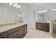 Dual vanities in bathroom boasting granite countertops, dark wood cabinets, tile flooring, and walk-in shower at 24407 Riverfront Dr, Punta Gorda, FL 33980