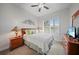Charming bedroom with ceiling fan, decorative wall art, window with wooden slat blinds, and carpet flooring at 24407 Riverfront Dr, Punta Gorda, FL 33980