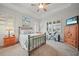 Bright bedroom features carpet flooring, a ceiling fan, a large window with wood slat blinds, and neutral paint at 24407 Riverfront Dr, Punta Gorda, FL 33980