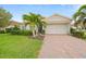 Charming single-story home with a well-maintained front yard, paver driveway, and decorative landscaping at 24407 Riverfront Dr, Punta Gorda, FL 33980