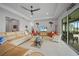Spacious living room featuring neutral paint, ceiling fan, tile floors, and direct access to the screened lanai at 24407 Riverfront Dr, Punta Gorda, FL 33980
