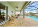 Inviting covered patio includes a seating area and dining set overlooking the pool and lake at 24407 Riverfront Dr, Punta Gorda, FL 33980