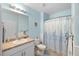 Cozy blue bathroom with white fixtures, including a toilet, vanity, and shower with decorative curtain at 25292 E Lenox Cir, Punta Gorda, FL 33950