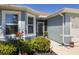 Charming home entrance with blue siding, flower decorations and well-maintained landscaping at 25292 E Lenox Cir, Punta Gorda, FL 33950