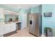 Open-concept kitchen with stainless steel refrigerator and seamless connectivity to the living area at 25292 E Lenox Cir, Punta Gorda, FL 33950