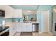 Well-equipped kitchen features stainless steel appliances, white cabinetry, and easy access to living room at 25292 E Lenox Cir, Punta Gorda, FL 33950