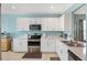 Modern kitchen with white cabinetry, stainless steel appliances, and ample counter space at 25292 E Lenox Cir, Punta Gorda, FL 33950