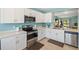 Bright kitchen features white cabinets, stainless steel appliances, and tile flooring at 25292 E Lenox Cir, Punta Gorda, FL 33950