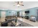 Comfortable living room with tile floors, a ceiling fan, and a view into the adjacent kitchen at 25292 E Lenox Cir, Punta Gorda, FL 33950