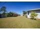 Backyard with green lawn, mature trees, and privacy fence at 3753 Aba Ln, North Port, FL 34287