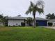 Charming single-story home with lush lawn, mature landscaping, and a vibrant blue garage door, radiating curb appeal at 3753 Aba Ln, North Port, FL 34287