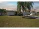 Charming one-story home showcasing a manicured lawn and mature palm, offering inviting curb appeal with its long driveway at 3753 Aba Ln, North Port, FL 34287